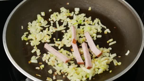 Female hand adds bacon to the pan and fry with onion. Close up — Stock Footage Female hand adds bacon to the pan and fry with onion. Close up Video Clip