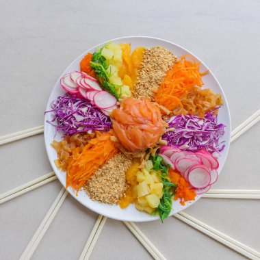 Colorful and circular arrangement of chinese festive cuisine / Carousel of Prosperity Toss / Radish, carrot, mandarin orange, jelly fish, pineapple, smoked salmon, baby octopus, deep fried fish skin clipart