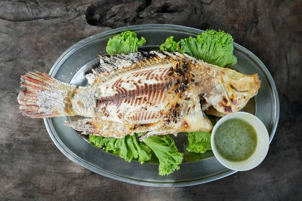 Popüler Çin mutfağı. Tuz Tilapia ile Çince otlar pişmiş. Tuz ve karnı içinde Çince otlar ile fırında kaplı, yenmiş taze kokulu koku ve lezzet, beyaz pilav yemiş verir