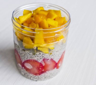 Mango küpleri, çilek dilimleri, chia tohum ve kabak çekirdeği ile ev yapımı soğuk ve tatlı tatlı üst. Chia tohum puding. Sağlıklı, lezzetli ve yüksek diyet lifi