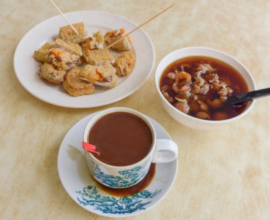 Tatlı bitkisel çorba ile geleneksel Asya kahvaltı, yam ve sütlü kahve fincan ile derin kızarmış nian gao