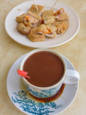 Sütlü kahve fincan yam ile derin yağda kızartılmış nian gao ile servis