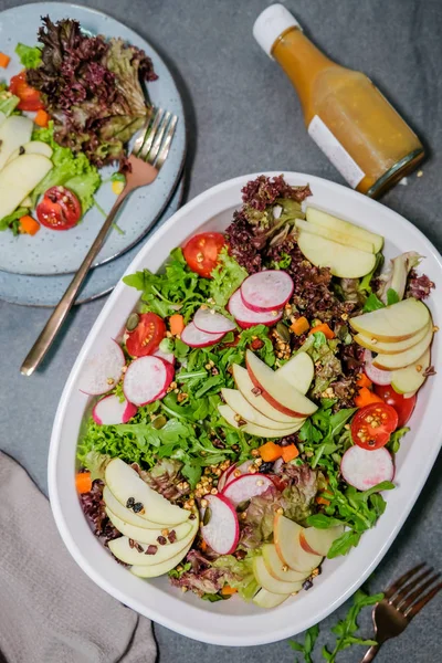 Gri arka planda sebze, meyve ve yeşillik ile taze salata 