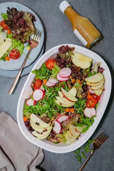 Gri arka planda sebze, meyve ve yeşillik ile taze salata 