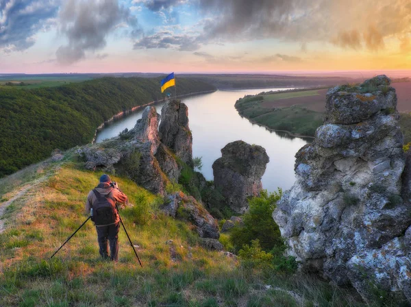 tourist on a cliff above the canyon. person on a cliff above the picturesque river. spring dawn