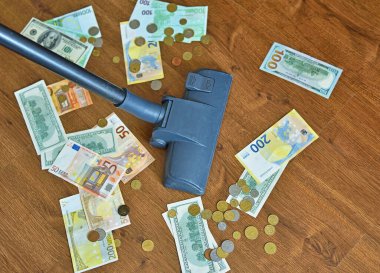Elektrikli süpürge ve yerde para.