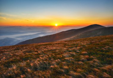 Dağlık bölgede şafak sökmeden önce. Sisin içindeki dağ siluetleri