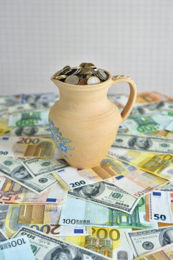 Para dolu bir masada bozuk paralarla dolu bir sürahi.