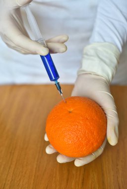 Şırınga ve turuncu ile bilim adamı