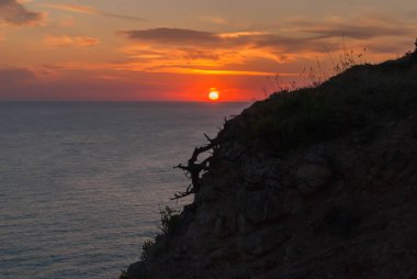 Gün batımı ve yanan bulutlar ve sakin deniz ile güzel bir deniz manzarası
