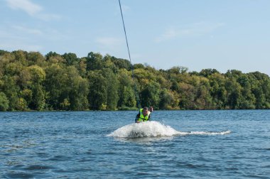 Nehirde wakeboard'a binen bir adam.