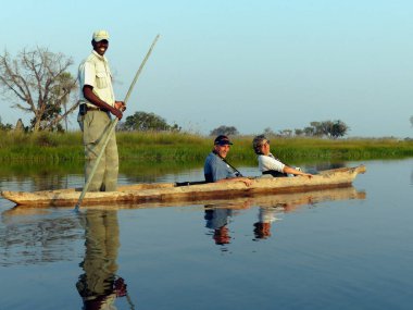 Moremi, Botsvana - Ağustos, 24, 2013: Okavango Deltası üzerinde safari ile Kano turistler Kılavuzu