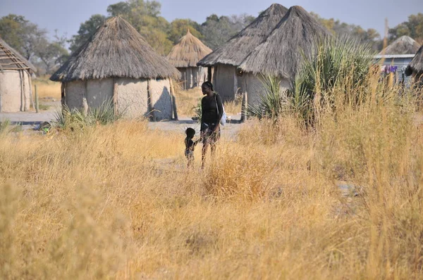 Moremi, Botsvana - Ağustos, 25, 2013: Afrika anne ve oğlu evleri duran