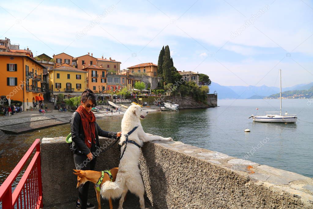 Young woman with dog visit Varenna village, Como lake