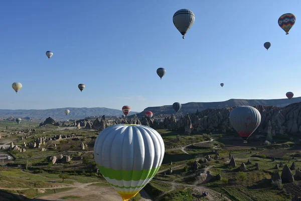 トルコ カッパドキアの珍しい岩の風景のパノラマビュー カラフルな熱気球は カッパドキア地域の深い渓谷 谷や妖精の煙突の上に空を飛びます — ストック写真