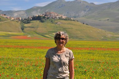 Olgun kadın çiçekaçan yaz çayır poz, Castelluccio, Norcia Köyü, Perugia Eyaleti, Umbria Bölgesi, İtalya