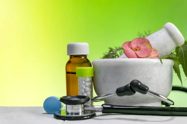 Alternative medicine concept  Homeopathic Healing herbs with a mortar and pestle with Stethoscope along with bottle of pills and liquid homeopathic substance