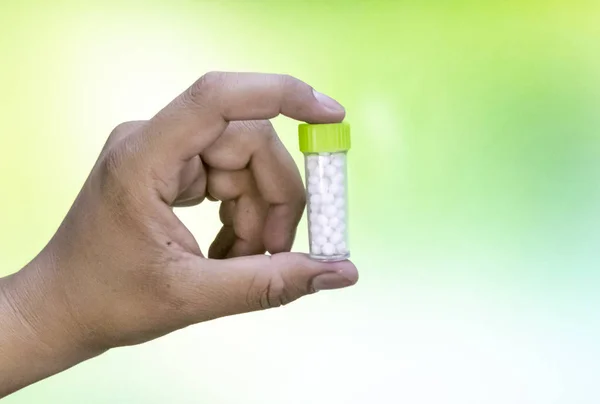 Homem Segurando Uma Garrafa Pílulas Homeopáticas Uma Mistura Verde Fundo — Fotografia de Stock