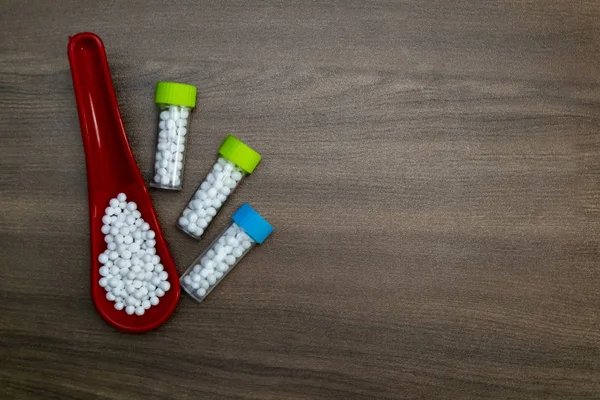 Garrafas Globulos Homeopatia Com Pílulas Colher Vermelha Fundo Madeira — Fotografia de Stock