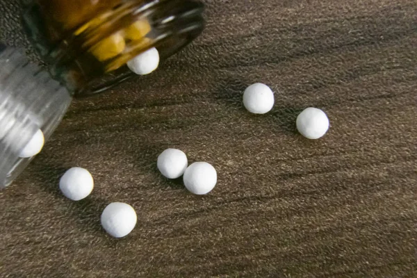 Image Rapprochée Globules Éparpillés Bouteilles Médicaments Homéopathiques Sur Fond Bois — Photo