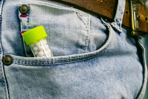 Homeopathic health concept - Homeopathic medicine bottle with pills in the pocket of a Jeans