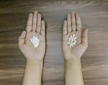 Homeopatik ve allopatik arasındaki farkı gösteren ilaçlar tutan adam elleri