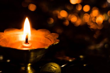 Pirinç bir lambayı bozuk para yığınına kapat - Diwali konsepti