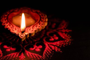 Diwali kutlama konseptinde siyah arka planda parlayan bir toprak lambanın yakın plan çekimi.