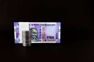 Para yığını ve para destesi, zenginlik kavramının oluşturulmasında fotokopi alanı ile siyah arkaplana karşı çekim yapıyor.