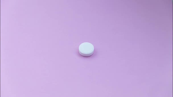 A variety of pills lie on a lilac background, — Stock Video