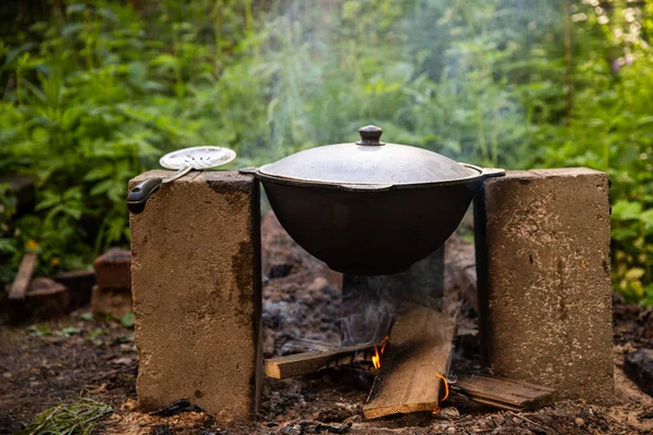 cooking pilaf in a cauldron, eating in a hike, summer leisure