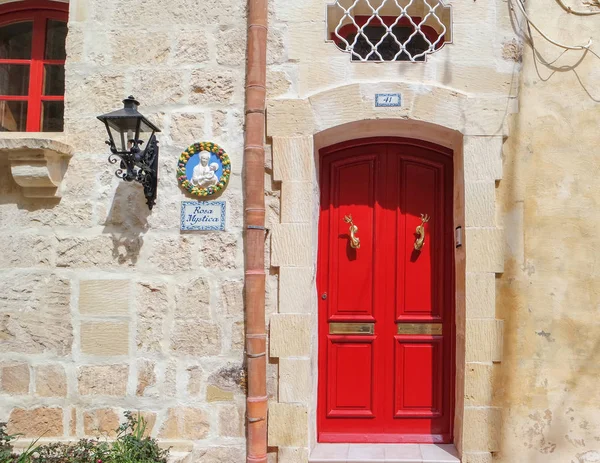 Alte rote Tür mit dekorativer Laterne an der Wand in rabat (ir-rabat), malta — Stockfoto