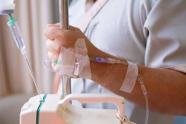 Nahaufnahme. männliche Hand mit einem Tropfer während einer Chemotherapie in einem Krankenhaus. Hand mit einer Pipette. Gesundheit ist ein Thema der Gesundheit und Heilung — Stockfoto