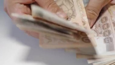 Thousansds Tay baht para sayma ellerini kapatın. Yakın Insan sayma Tay banknot, richman sayısı ve yüz tutan kadar. Masada Baht faturaları.