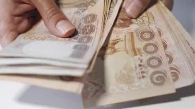 Thousansds Tay baht para sayma ellerini kapatın. Yakın Insan sayma Tay banknot, richman sayısı ve yüz tutan kadar. Masada Baht faturaları.