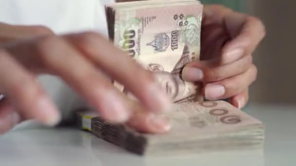 Närbild händer räkna av thousansds thailändska baht pengar. Närbild mänsklig räkning thailändsk sedel, Richman räkna och hålla hundra. Baht räkningar på bordet. — Stockvideo