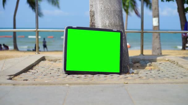 Porta TV sulla spiaggia. Televisione con schermo verde. Puoi sostituire lo schermo verde con il filmato o l'immagine che desideri . — Video Stock