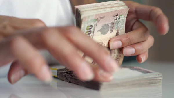 Close-up handen tellen van thousansds Thaise Baht geld. Close-up menselijk tellen Thaise bankbiljet, Richman tellen en het houden van honderd. Baht rekeningen op tafel. — Stockfoto