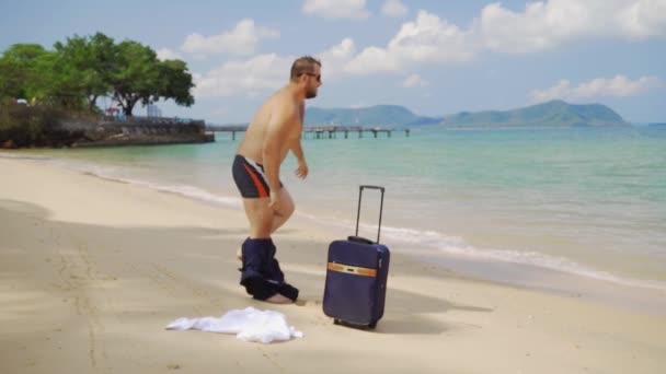 Uomo d'affari si spoglia sulla spiaggia e salta in mare. vacanza felice maschile. concetto freelance, concetto di svago tanto atteso — Video Stock