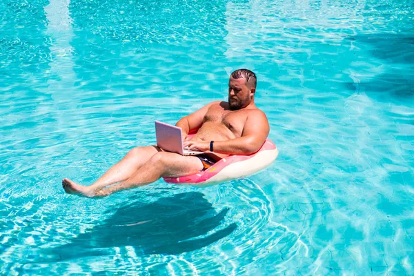 水の中のゴムリングにラップトップを持つ男性ビジネスマン — ストック写真