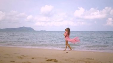 anne ve küçük kızı güzel bir mavi deniz, eğlence kavramı, aile kıyısı boyunca yürümek.