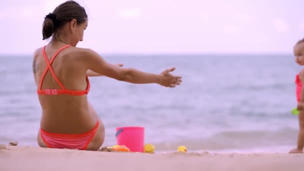 Mamá con sus niñas juega a abrazar y correr al mar. concepto de madres e hijas felices, concepto de felicidad y cremas para proteger la piel en el mar, niños felices — Vídeo de stock