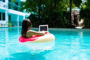 bir laptop ile havuzda şişme daire kız, freelancing ve rekreasyon kavramı.