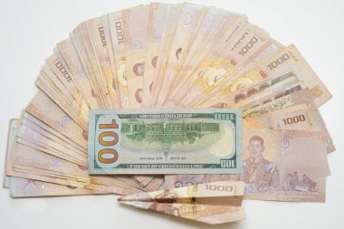 Tay baht bir yığın ve bir uçak ile beyaz bir masada yüz dolar.