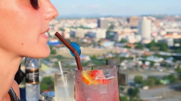 Kvinnlig dricka apelsin cocktail från ett strå, närbild — Stockvideo