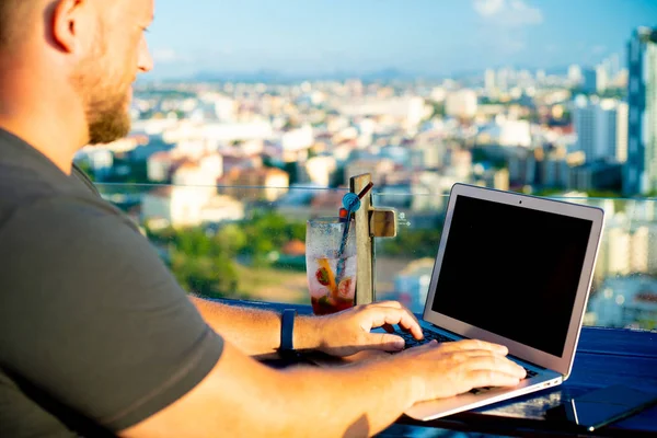 Hombre trabajando en una computadora en un café con una hermosa vista —  Fotos de Stock