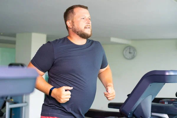 tombul adam koşu pistinde yürüyüş, spor salonu koşu bandı üzerinde ısınma.