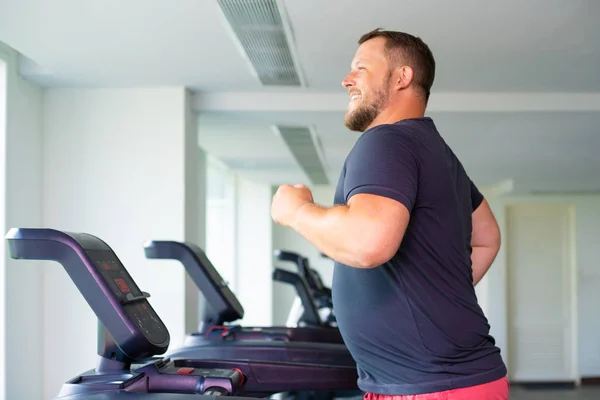 Pria gemuk berjalan di trek berlari, pemanasan di treadmill gym . — Stok Foto