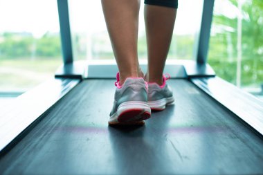 spor salonunda koşu bandı üzerinde kadın kaslı bacaklar, closeup.