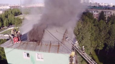 Nizhnevartovsk, Rusya - 1 Temmuz 2019: İtfaiyeciler yüksek katlı bir binanın çatısında çıkan yangını söndürdü